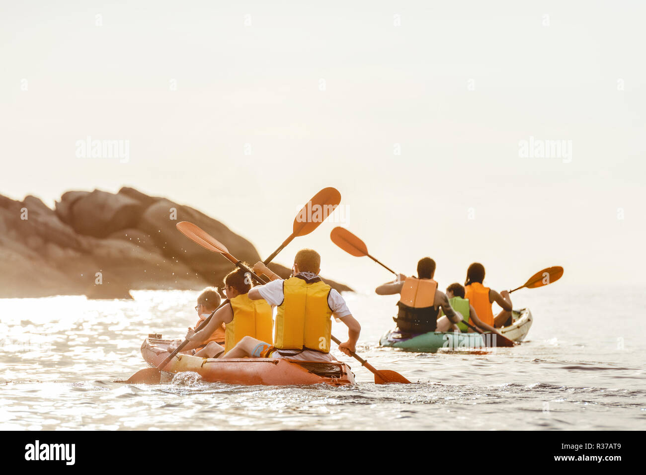 Zwei Familien Wanderungen mit dem Kajak oder Kanu bei Sonnenuntergang Meer Bucht. Kajak oder Kanu Konzept Stockfoto