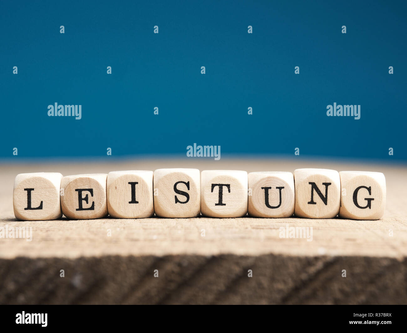 Kleine hölzerne Würfel mit dem deutschen Wort den Aufwand für eine Tabelle Stockfoto