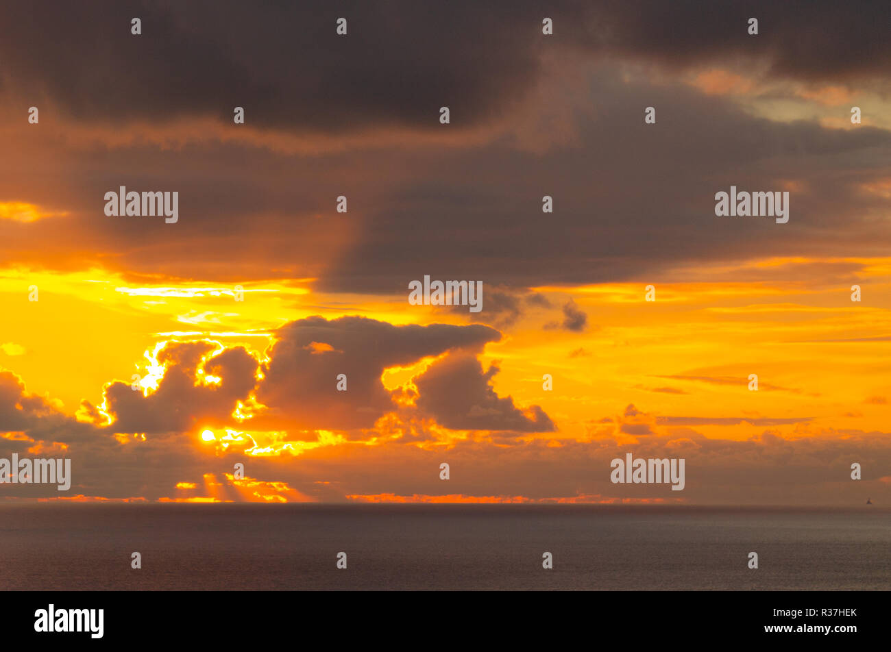 Sonnenaufgang oder Sonnenuntergang durch Gewitterwolken über den Atlantik Stockfoto