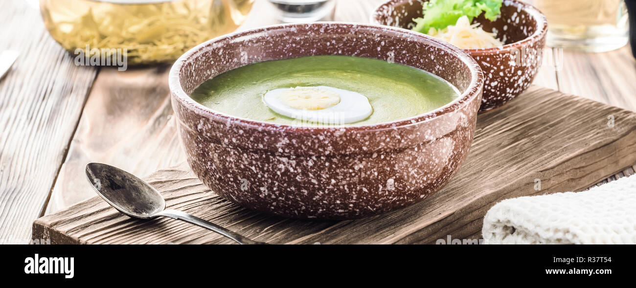 Püree Cremesuppe von grünem Salat, Spinat und Käse in der Schüssel dekoriert Stück gekochtes Ei an Bord für Gerichte auf den Tisch, serviert mit Stockfoto