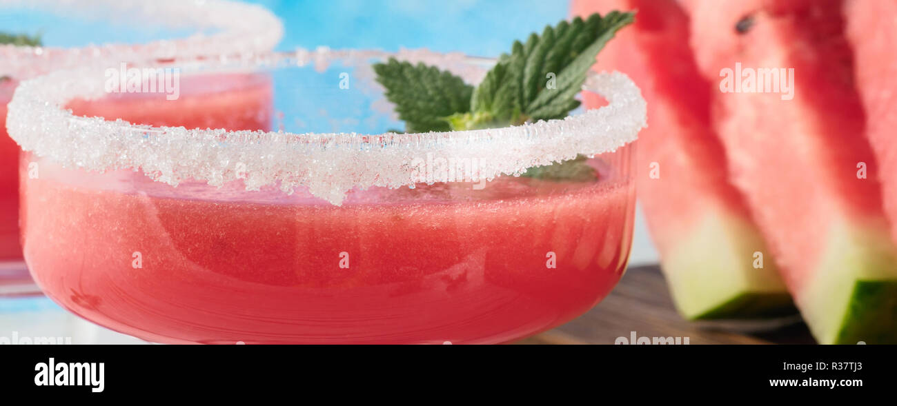 Trinken Smoothies aus roten Wassermelone in Glas Geschirr eingerichtet Weißzucker und Minze Stück Obst auf schneidbrett Weiß und Blau backgr Stockfoto