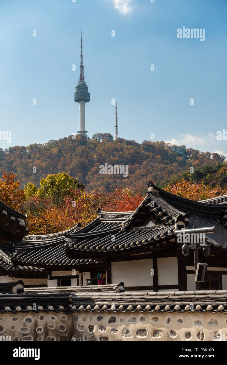 Einen Ausblick auf Namsan Tower über die Dächer der Häuser am Namsangol Hanok Village, Seoul, Südkorea an einem Herbsttag. Stockfoto