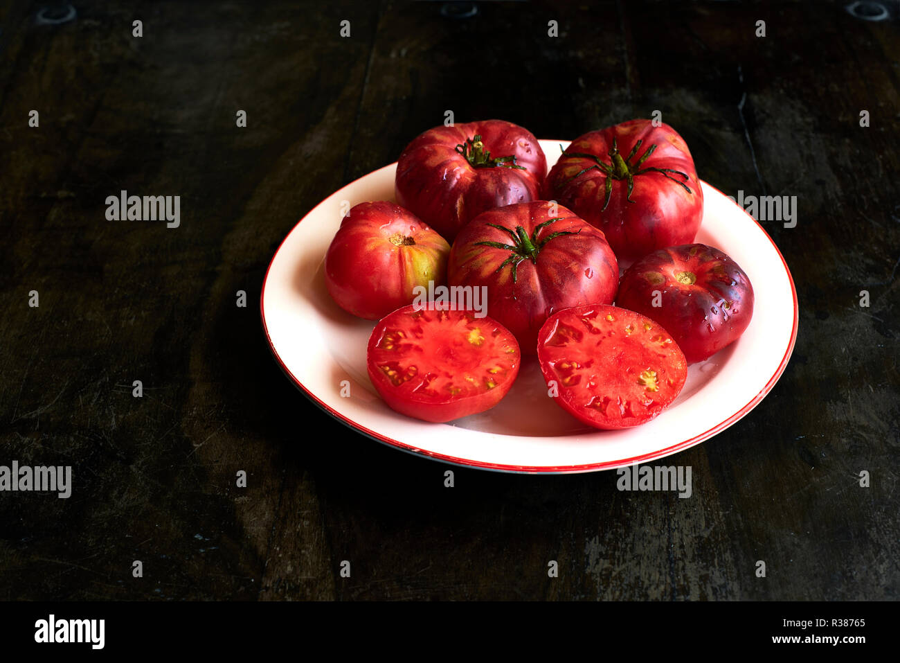 Reif Tibet Apple Tomaten über eine rustikale Tabelle. Stockfoto