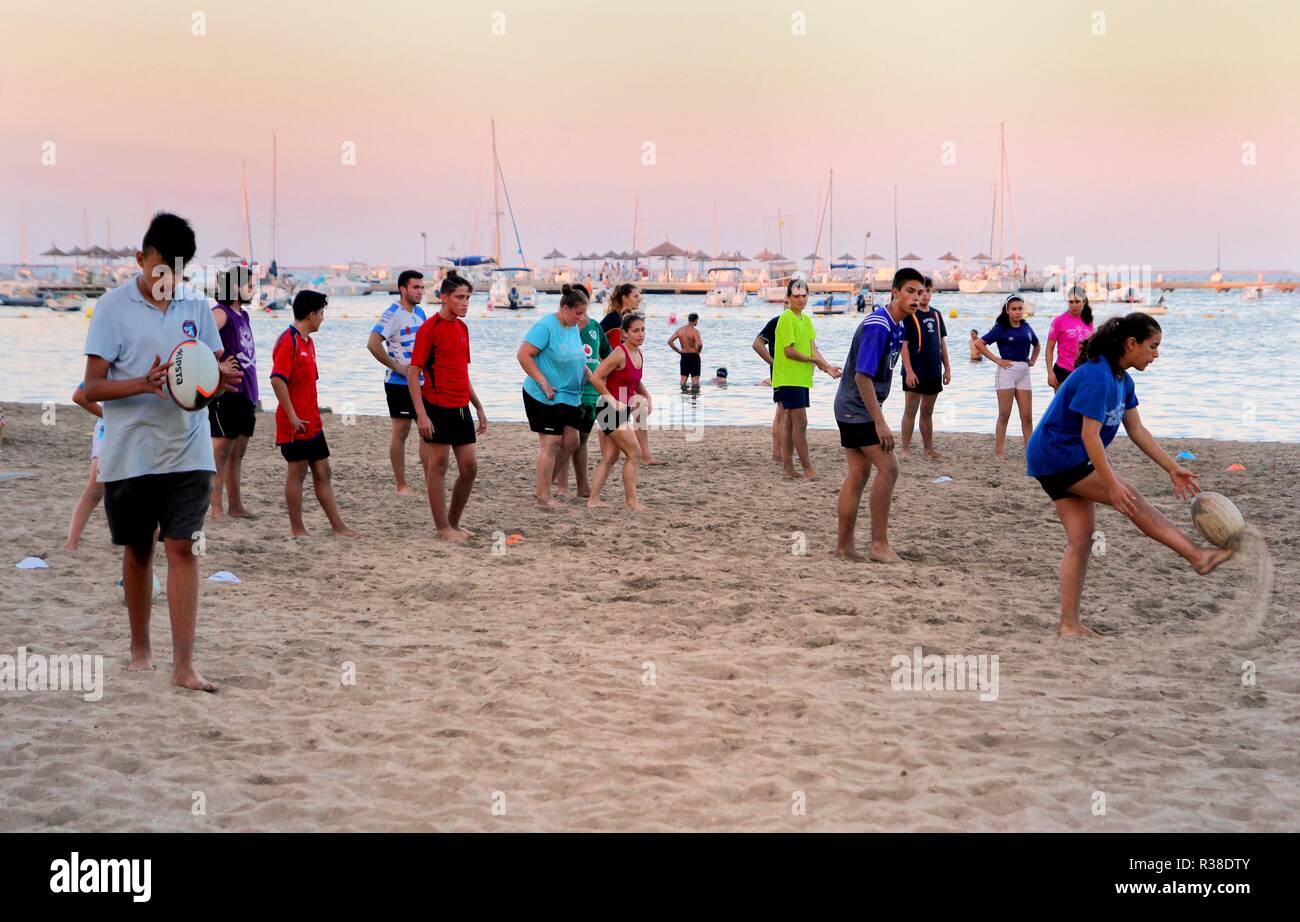 Santiago de la Ribera, Murcia, Spanien - 31. Juli 2018: Jugendliche und junge Leute spielen Beach Rugby an einem warmen Sommerabend Stockfoto