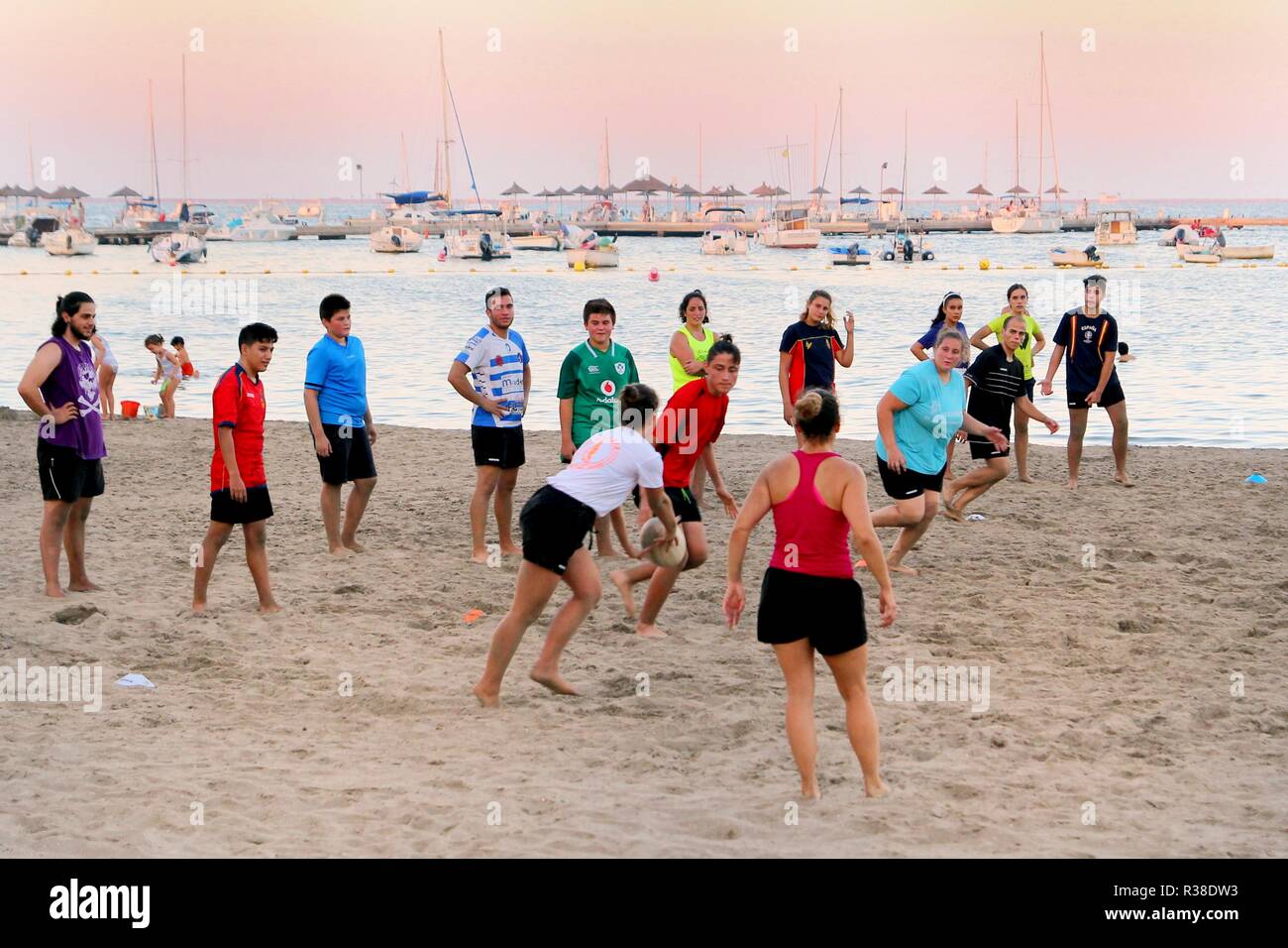 Santiago de la Ribera, Murcia, Spanien - 31. Juli 2018: Jugendliche und junge Leute spielen Beach Rugby an einem warmen Sommerabend Stockfoto