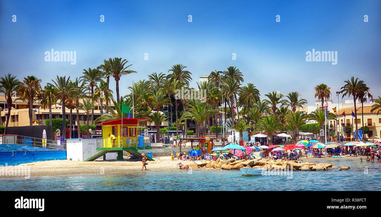 Santiago de la Ribera, Murcia, Spanien - 06. August 2018: Der Bademeister stationnext zu einem belebten Strand voller Urlauber, mit hohen Palmen in der Ba Stockfoto