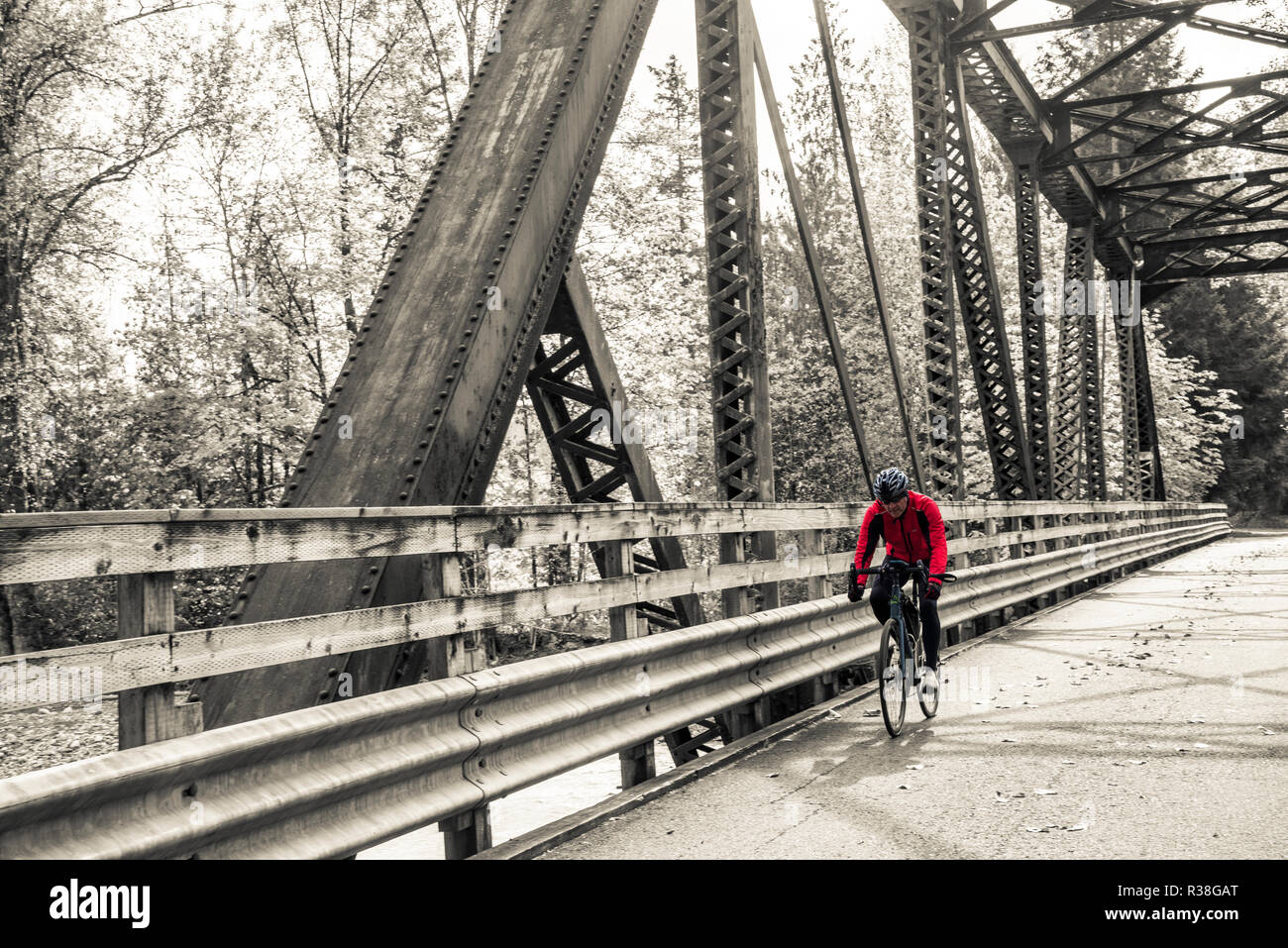 Mann, sein Fahrrad über alte Brücke aus Metall Stockfoto