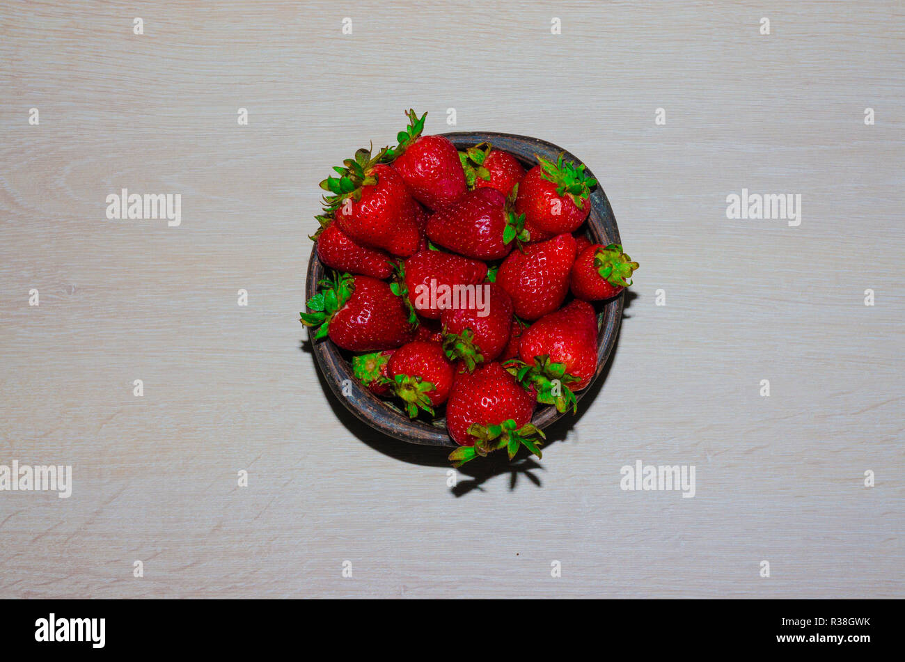 Fresas frescas maduras Rojas y sobre vasija de greda Stockfoto