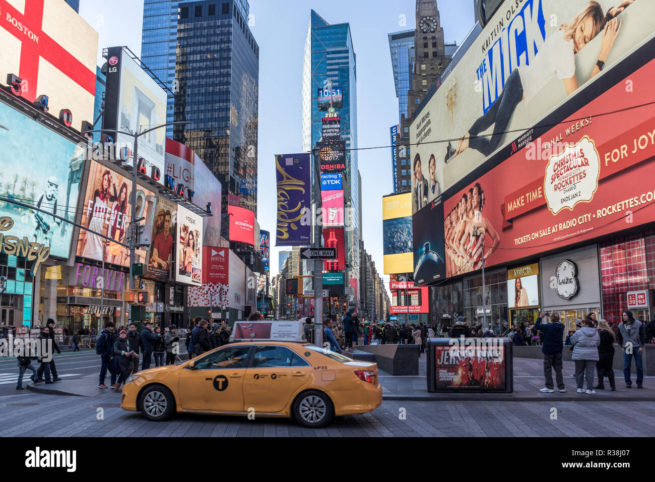 New York City, USA - 25. Dezember 2016: Time Square ein gelbes Taxi fahren, eine Masse von Menschen zu Fuß, auf dem Bürgersteig, und Werbung si Stockfoto