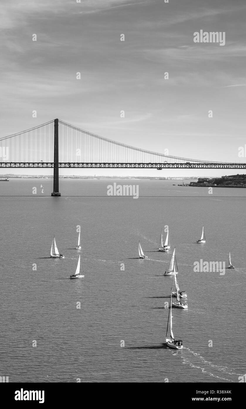 Segelboote auf dem Rio Tajo mit Ponte 25 de Abril, monochrom, Lissabon, Portugal Stockfoto