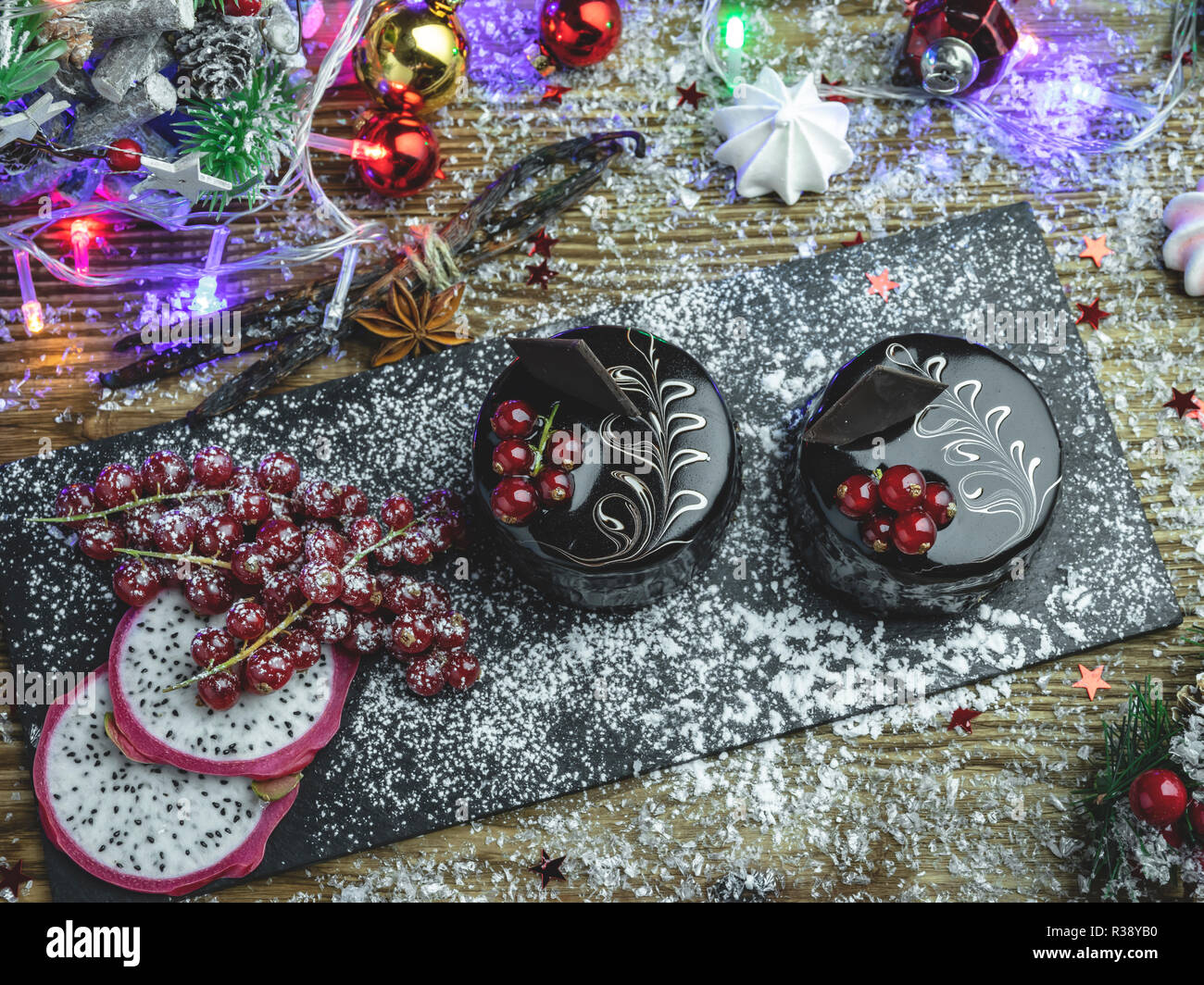 Schokoladenkuchen mit roten Johannisbeeren. Tasse Kaffee mit Dessert auf den Tisch. Neues Jahr Weihnachten Zusammensetzung, Dekoration. Stockfoto