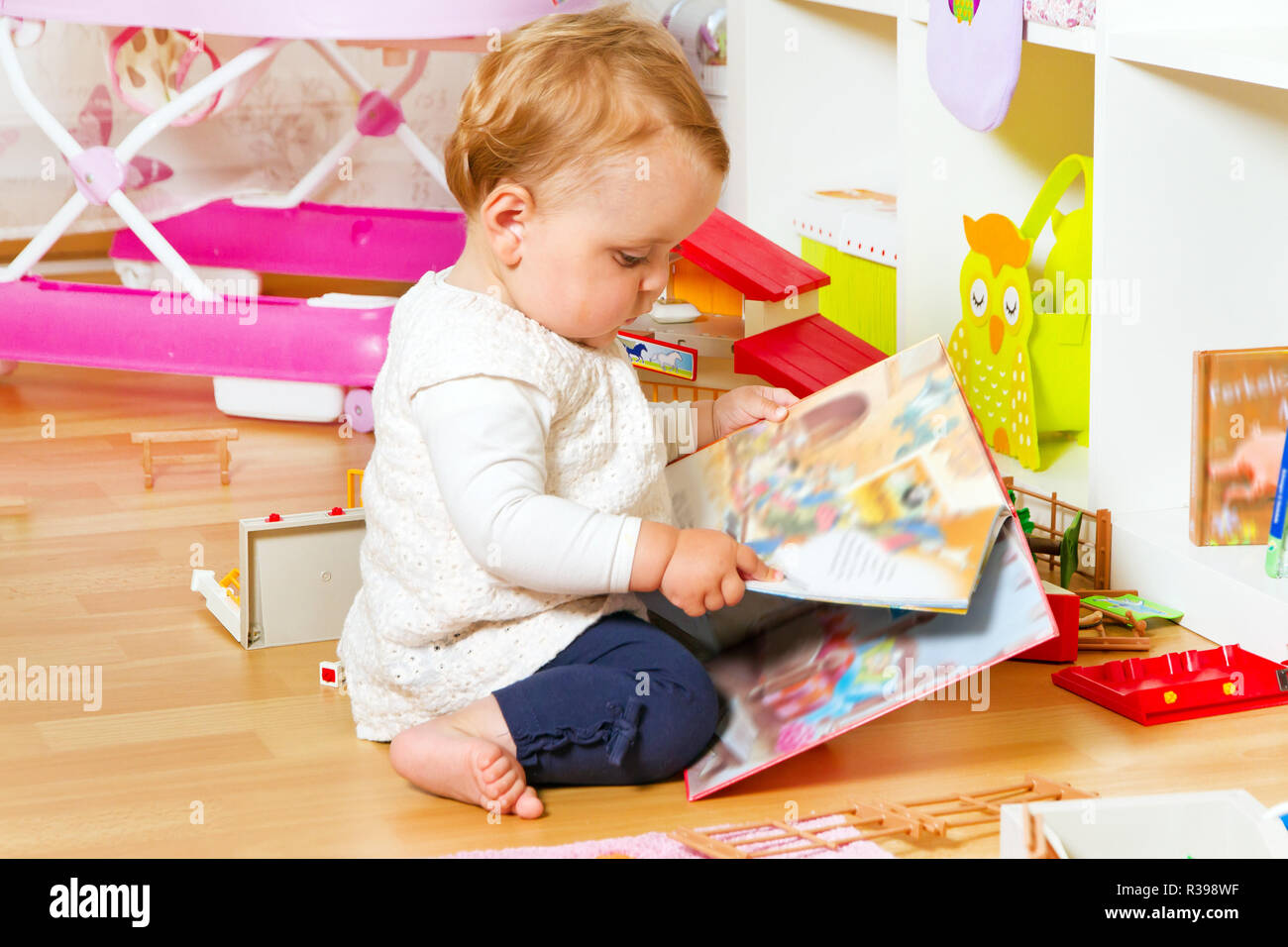 Kleines Baby mit einem Bilderbuch Stockfoto