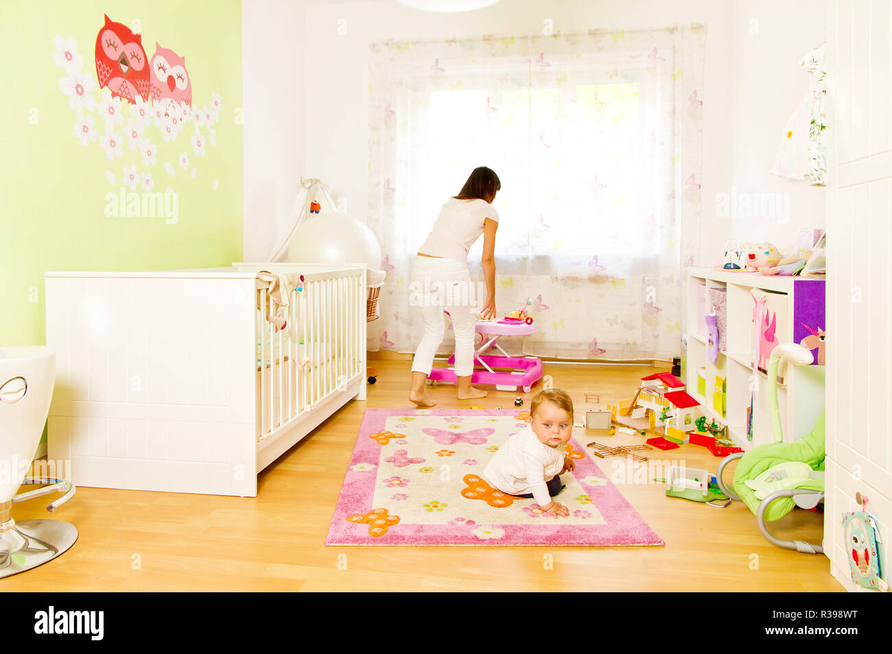 Junge Mutter mit Baby im Kinderzimmer Stockfoto
