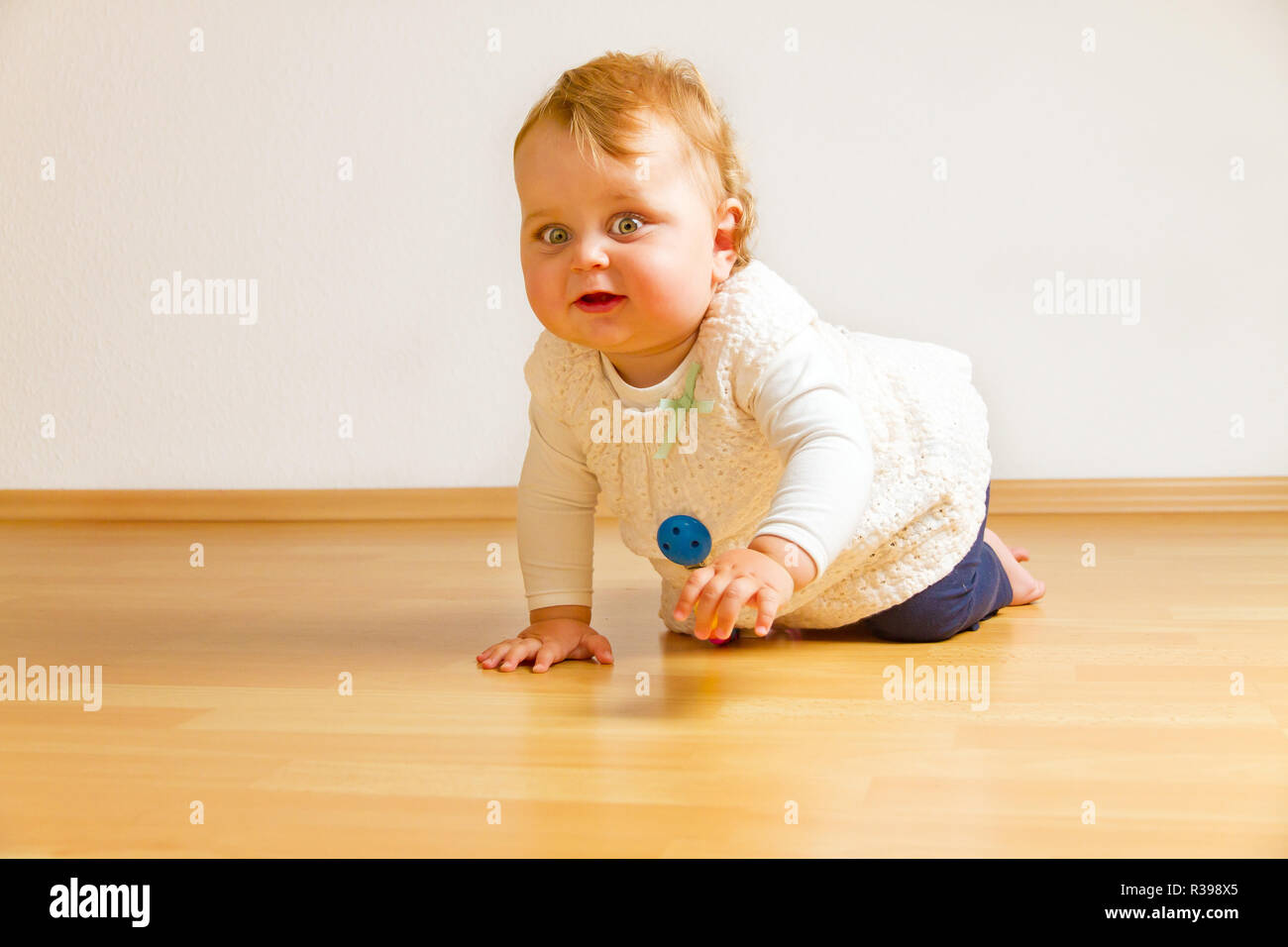 Baby krabbeln auf dem Holzboden Stockfoto