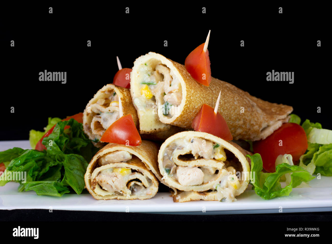 Huhn Pfannkuchen mit Salat innen mit isolierten schwarzen Hintergrund Stockfoto