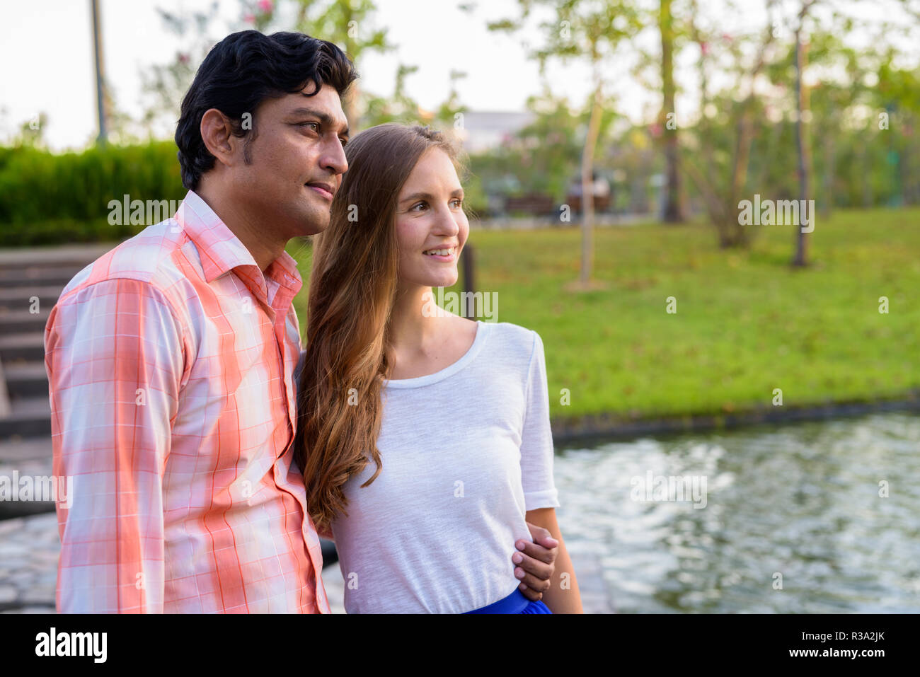 Glücklich, multi-ethnische paar Lächeln beim Denken auf Stein weg i Stockfoto