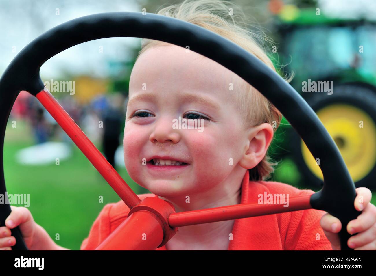 St. Charles, Illinois, USA. Little Boy genießen Lenkung einer stationären Traktor mit einer Touch-a-Traktor Ereignis von einer farm bureau gehostet werden. Stockfoto
