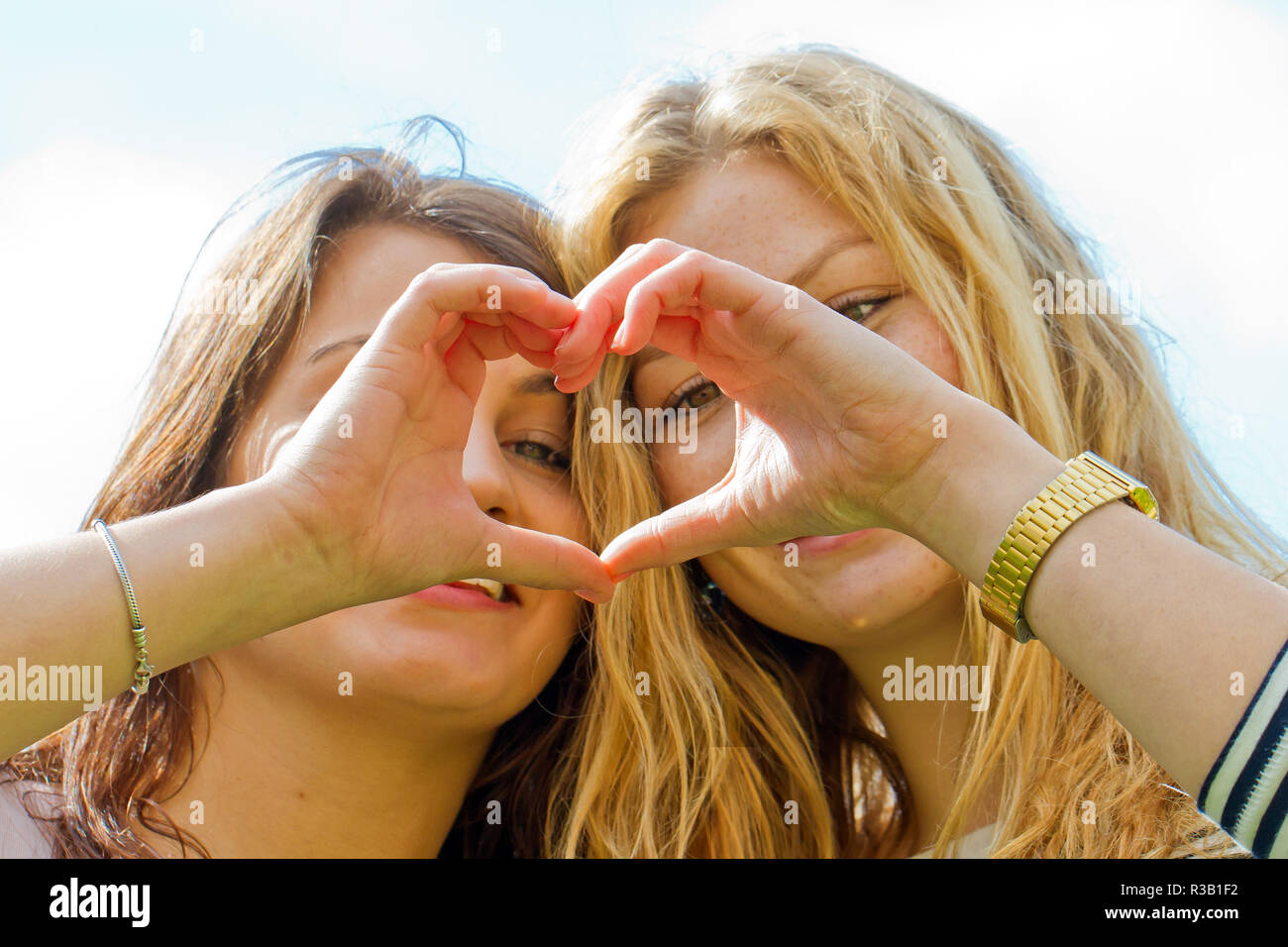 Zwei Freundinnen machen einen Finger Herz Stockfoto