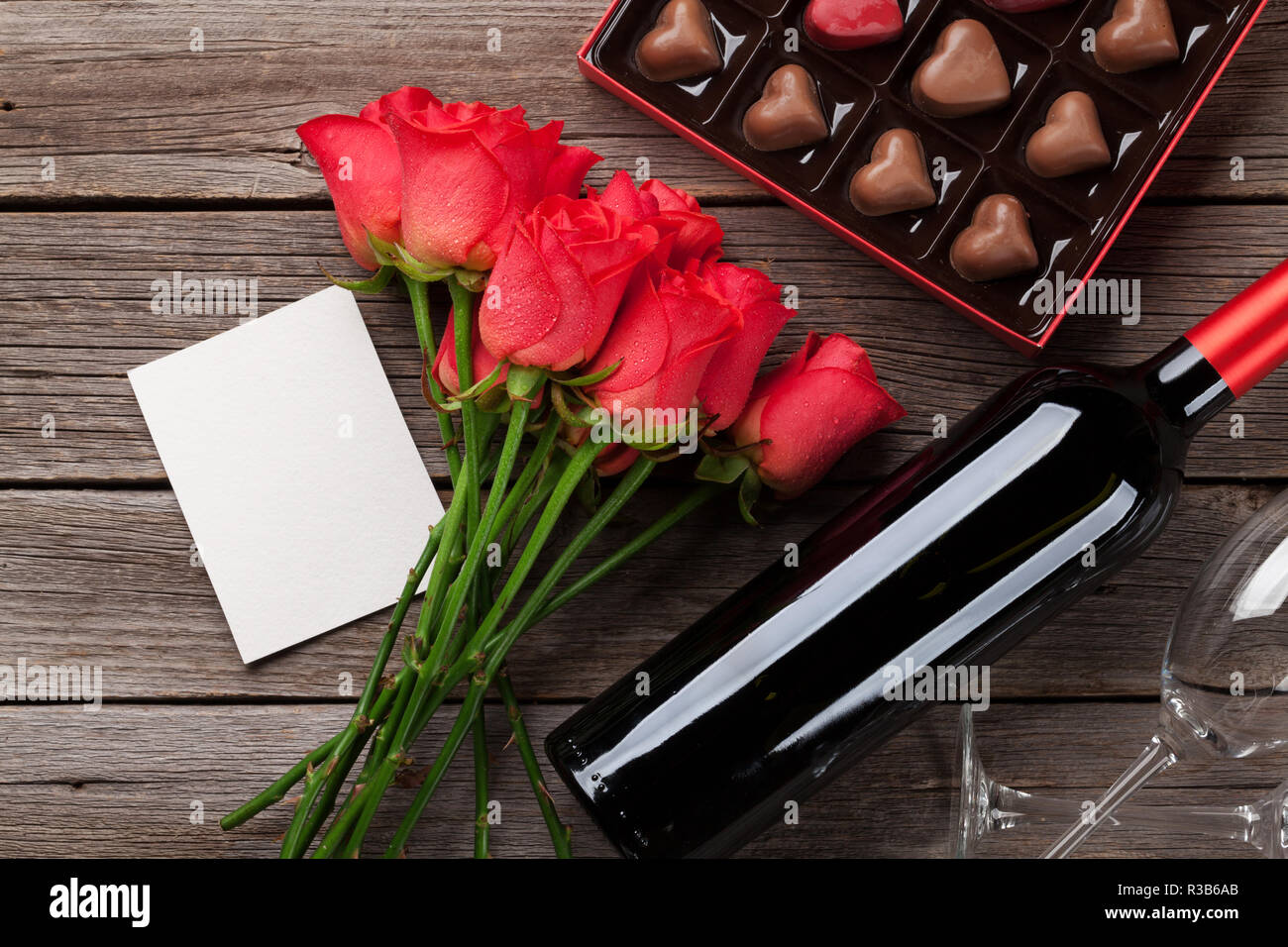 Valentines Tag mit roten Rosen, Flasche Wein und Schokolade Kasten auf  Holztisch. Ansicht von oben mit Platz für Ihren Text Stockfotografie - Alamy