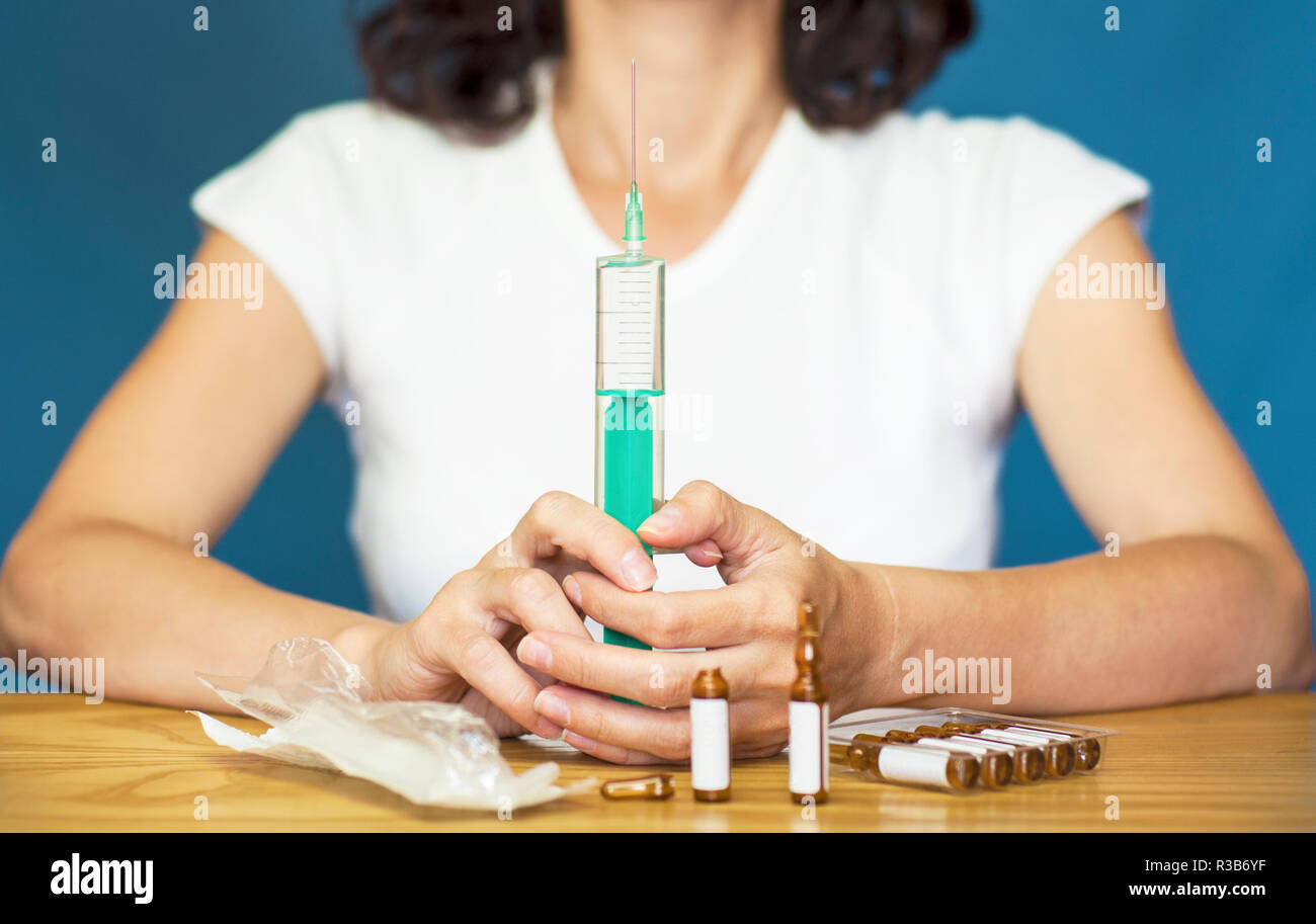 Frau mit einer Spritze, die mit dem Impfstoff zum Schutz gegen Grippe Stockfoto