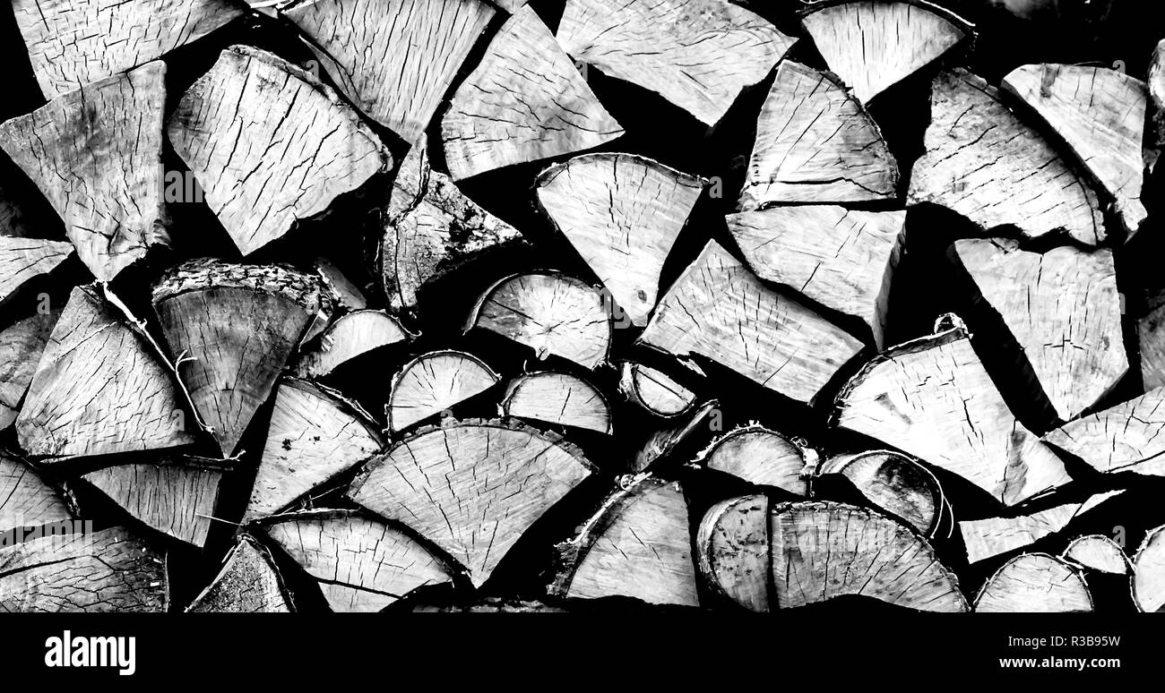 Holzstapel Textur. Stückholz closeup in Schwarz und Weiß. Cut Brennholz für den Winter. Schwarzen und weißen Hintergrund aus Baumstämmen. Stockfoto