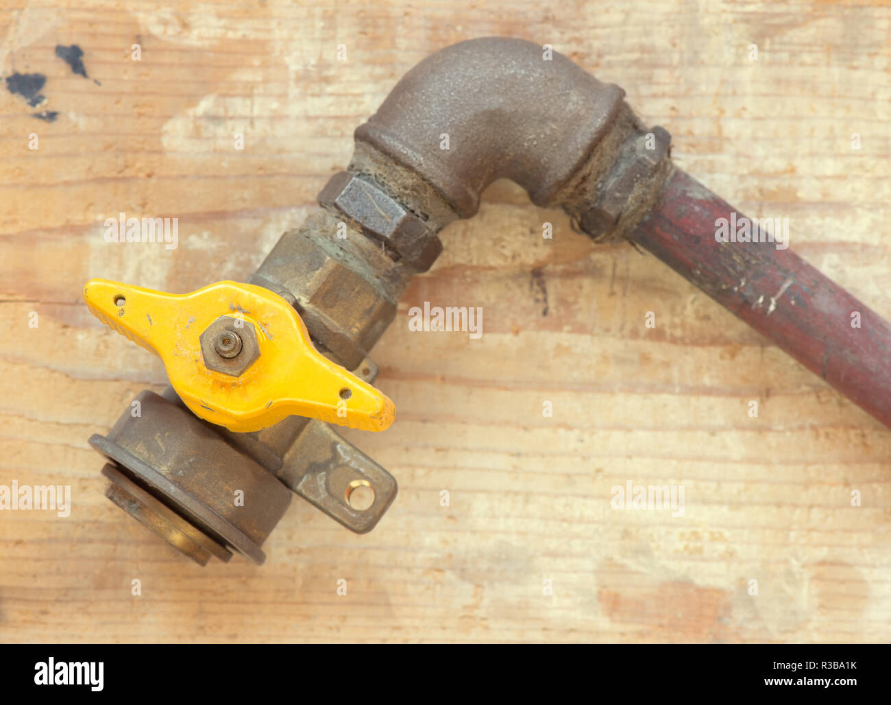 Alte Gas mit gelben Kugelventil auf Holz- Hintergrund Stockfoto