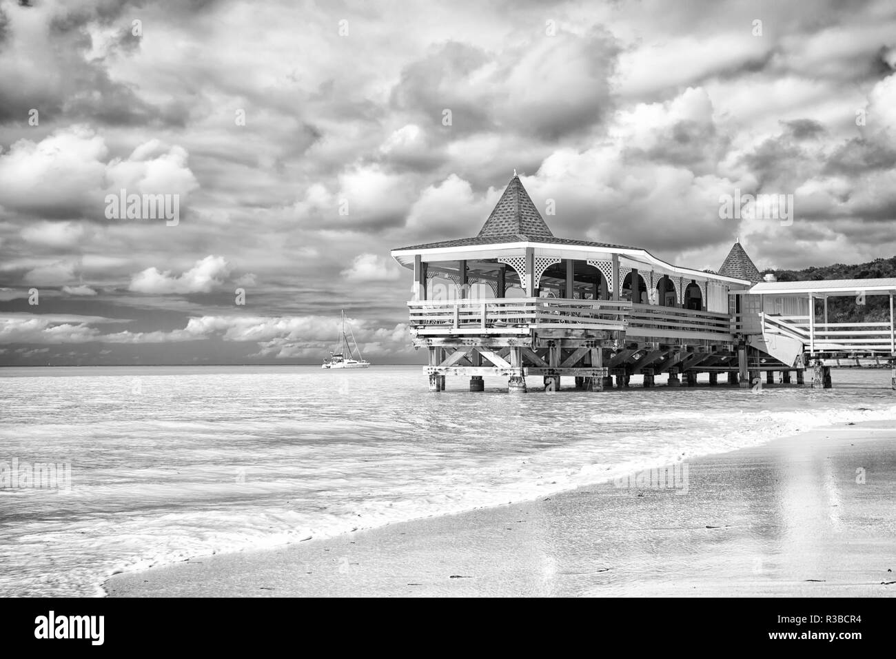 Meerblick Bungalow Ferien. Meer türkisblaues Wasser und Bungalow Haus. Ferienhäuser Meer Sandstrand tropischen Haus Bungalow st johns stürmischen Tag Antigua. Dramatische Wolkenhimmel am Meer. Urlaub auf Inseln. Stockfoto