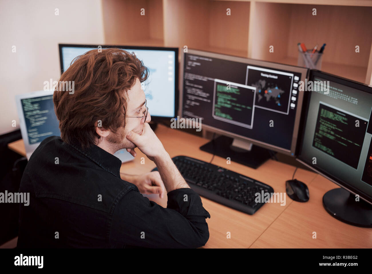 Männliche Programmierer arbeiten auf dem Desktop Computer mit vielen Monitoren an Büro in Software entwickeln. Web site Design Programmierung und Coding Technologies Stockfoto