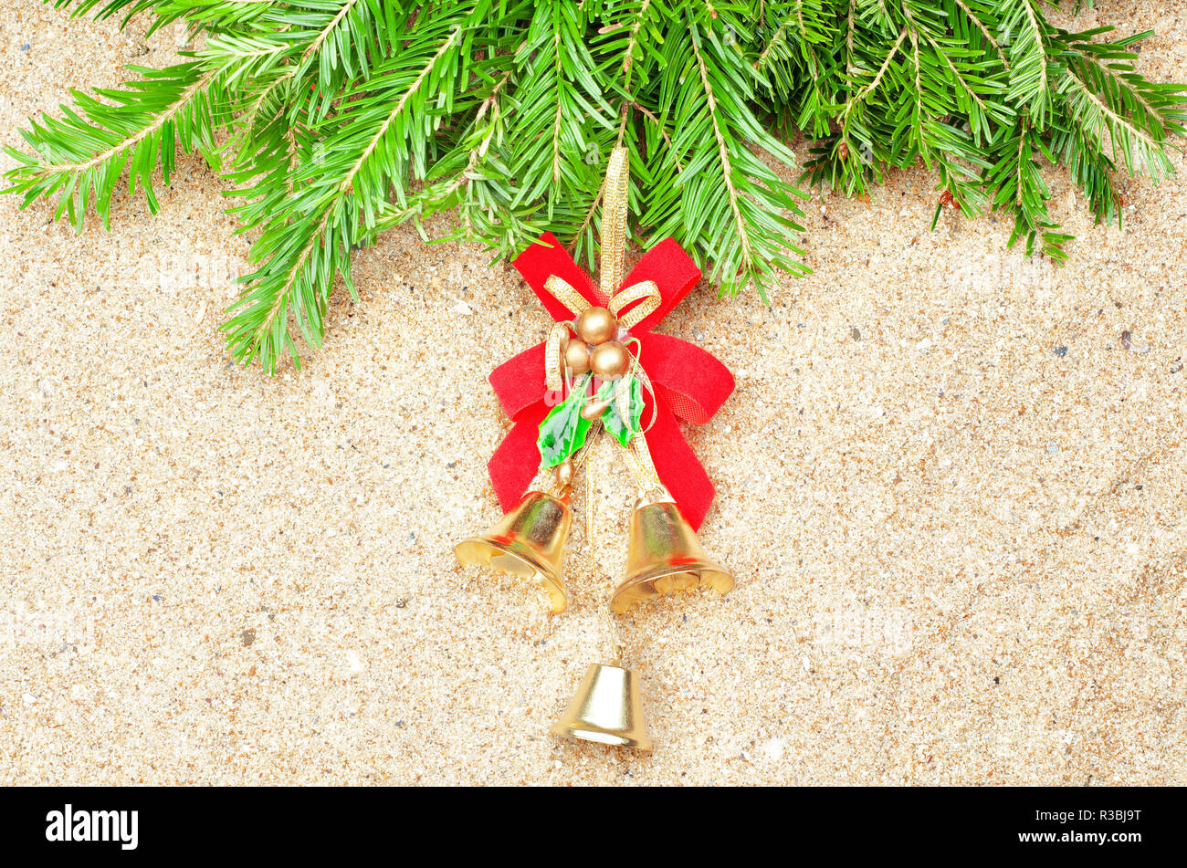 Weihnachtsschmuck Christmas Bells und Tanne im Sand Stockfoto