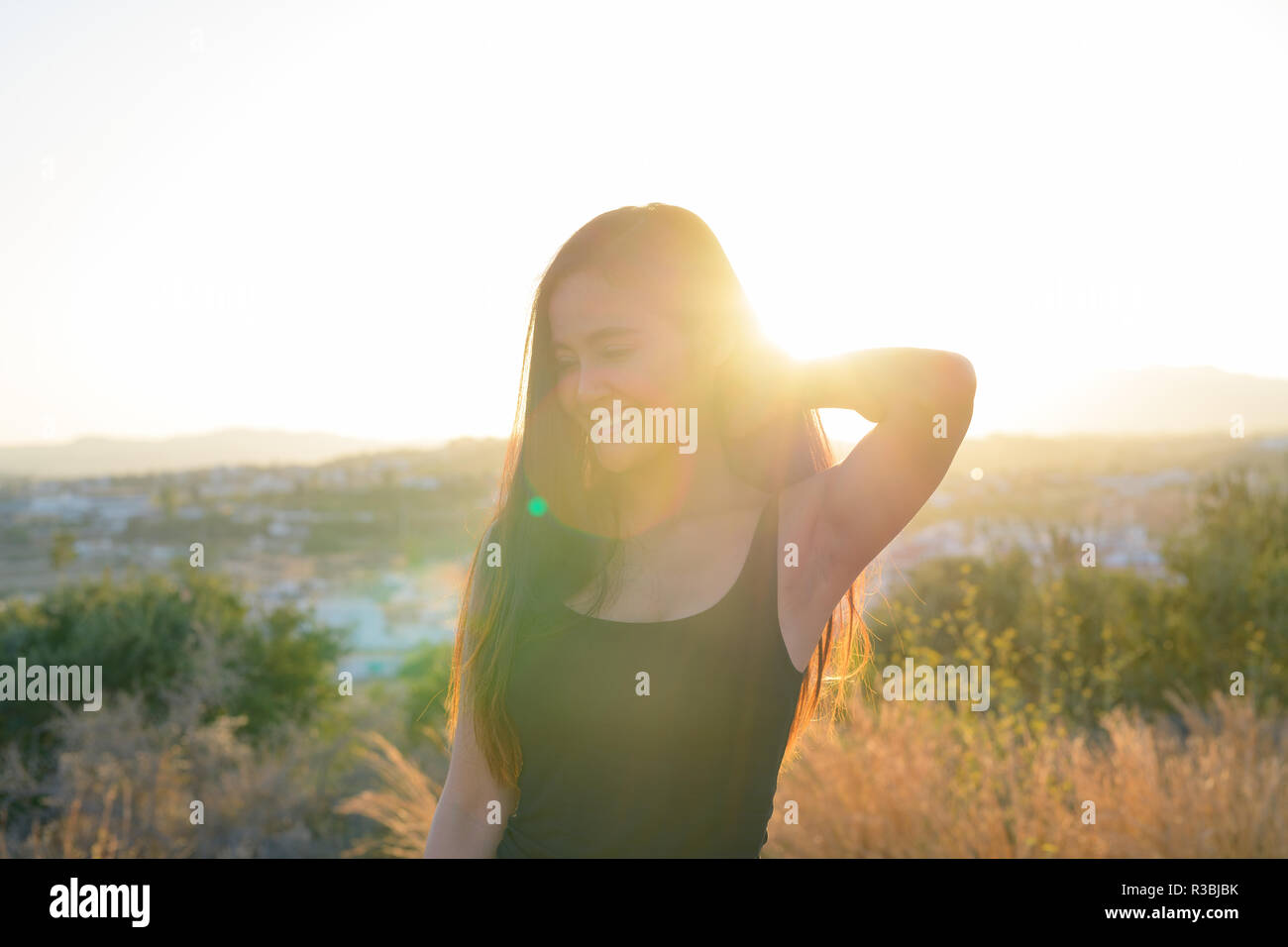 Junge schöne asiatische Tourist Frau lächelnd, während Sie gegen Sonnenlicht Stockfoto
