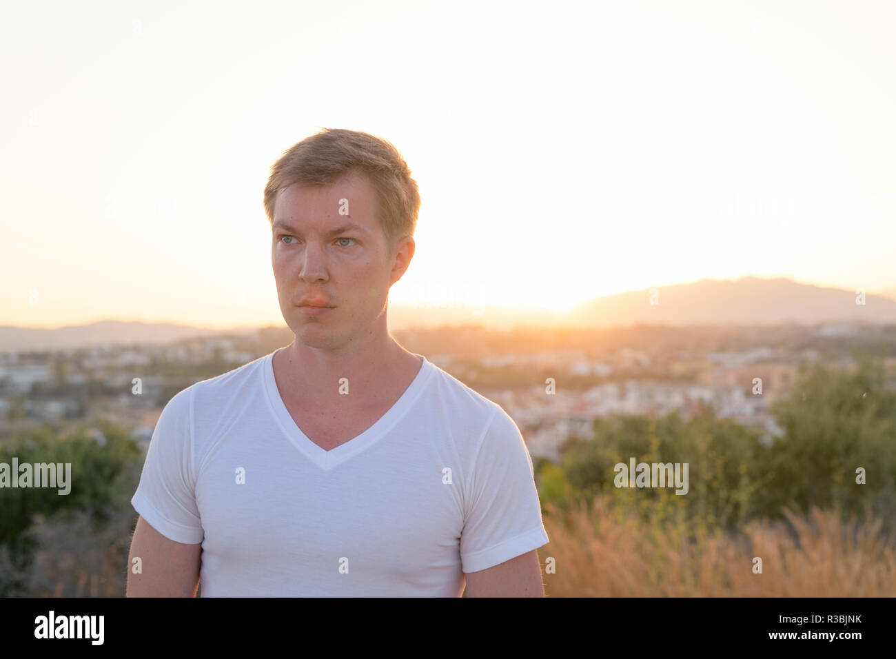 Junge Attraktive touristische Mann denken ganz oben auf dem Hügel Stockfoto
