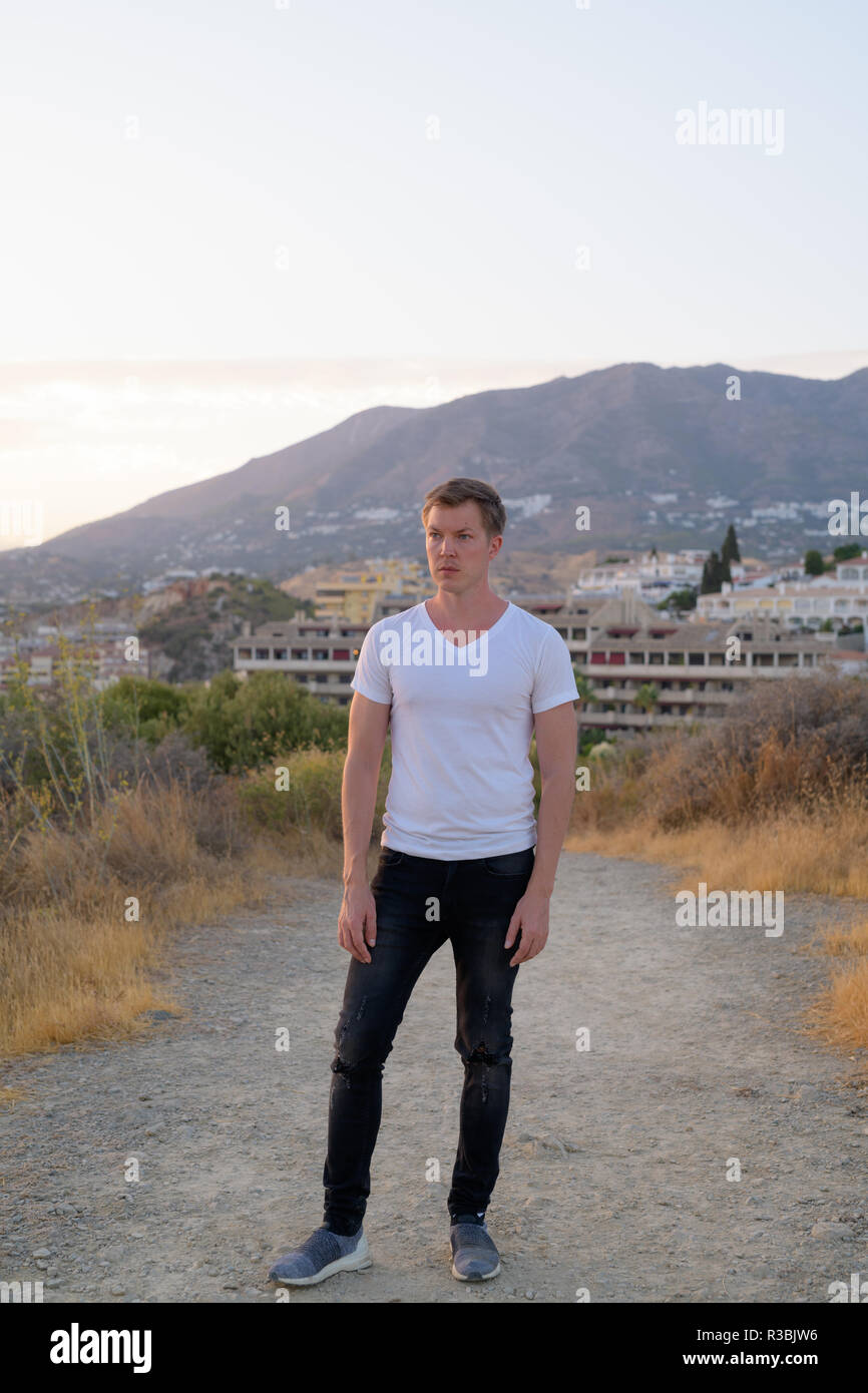 Junge Attraktive touristische Mann Denken beim Stehen auf der Spitze des Hügels Stockfoto
