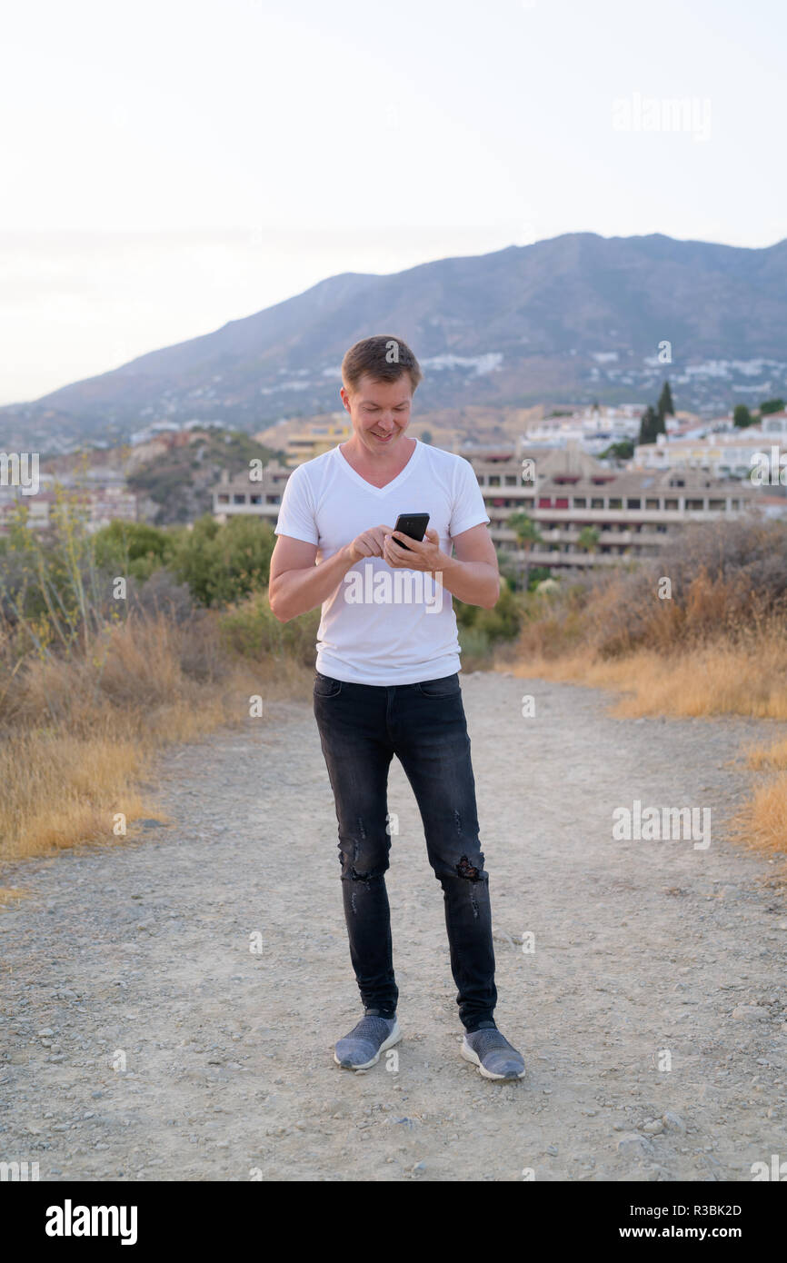 Junge gern mit touristischen Mann mit Phone beim Stehen auf der Spitze des Hügels Stockfoto