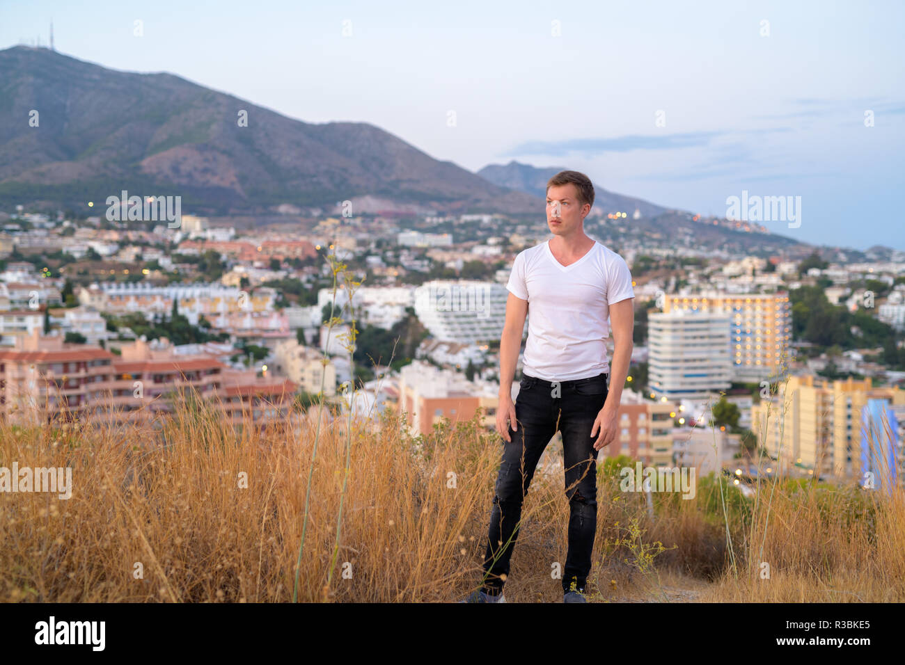 Junge Attraktive touristische Mann Denken beim Stehen auf der Spitze des Hügels Stockfoto