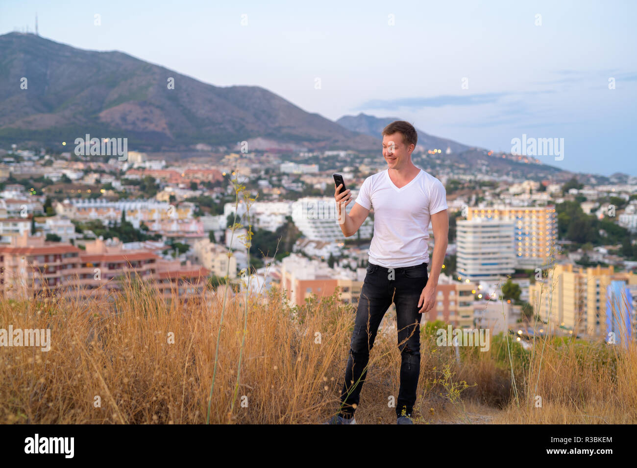 Junge gern mit touristischen Mann mit Phone beim Stehen auf einem Hügel mit Blick auf die Stadt Stockfoto