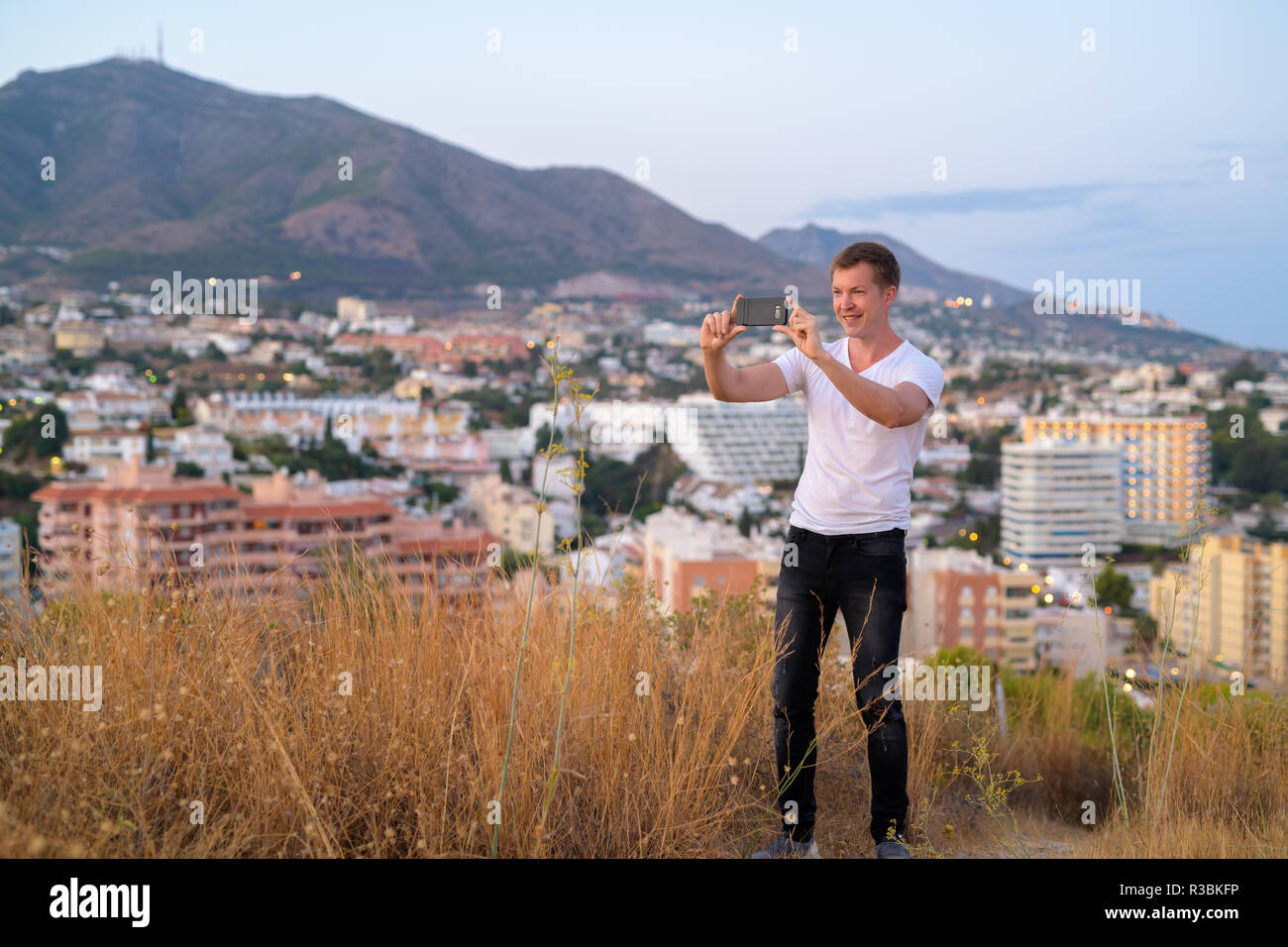 Junge gern mit touristischen Mann mit Handy beim Stehen auf einem Hügel mit Blick auf die Stadt Stockfoto