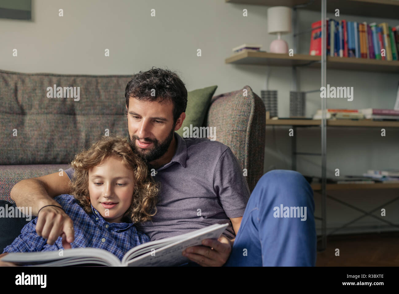 Lächelnd Vater und Sohn ein Buch zu Hause lesen Stockfoto