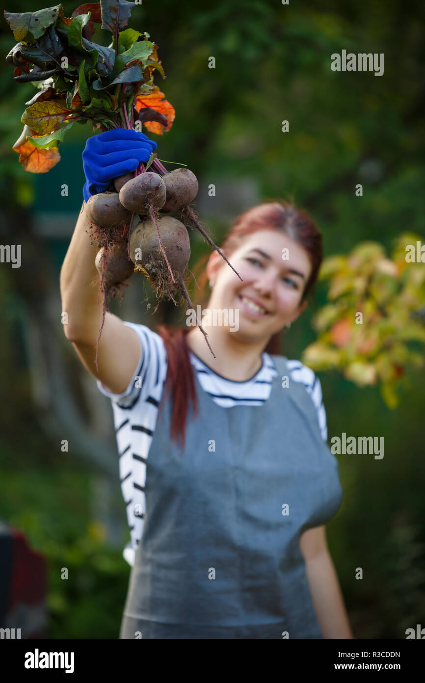 Foto der jungen Frau mit rote Beete im Garten, verschwommenen Hintergrund Stockfoto