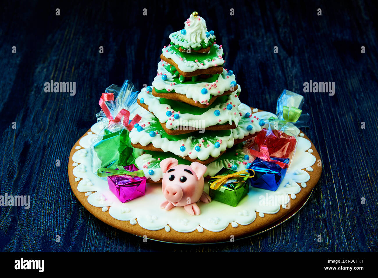 Weihnachten Lebkuchen, süßes Schwein mit Geschenken und Süßigkeiten im Paket  unter dem Weihnachtsbaum auf einem dunklen Hintergrund Stockfotografie -  Alamy