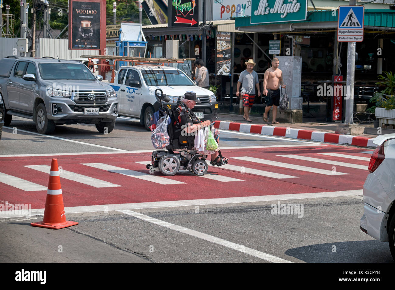 Rollstuhl behinderte Menschen in einen elektrischen Rollstuhl Überqueren  der Straße auf einem zebrastreifen gebunden. Thailand Südostasien  Stockfotografie - Alamy