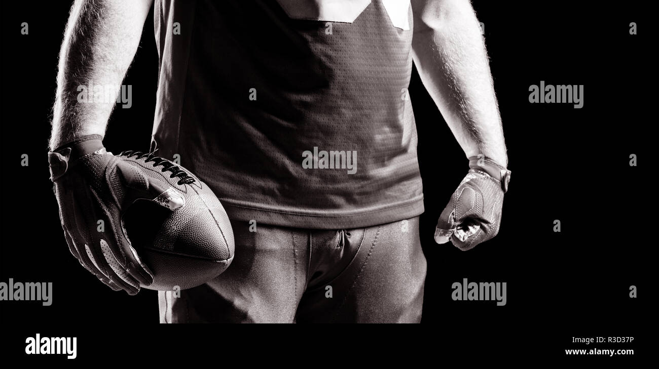 American football player stehend mit rugby ball Stockfoto