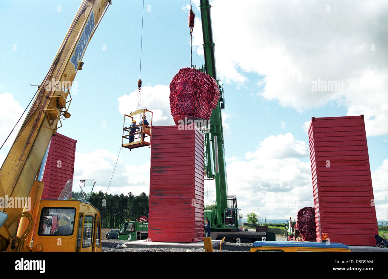 Eine der schottische Künstler, David Machs, 18 Tonnen schweren "Big Heids' Skulpturen an ihren Platz an der Seite der Autobahn M8 zwischen Glasgow und Edinburgh in Schottland absenken Stockfoto