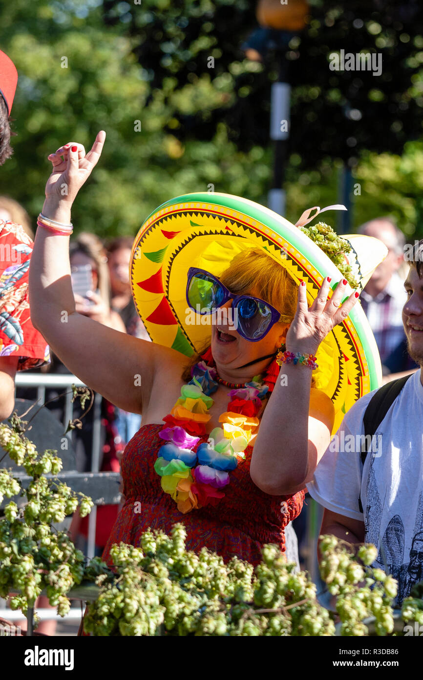 Faversham Hop Festival 2018. Reife Frau im Publikum tragen Aufblasbare gelb Mexikanischen sombrero, und über große Sonnenbrillen, Mitsingen. Stockfoto