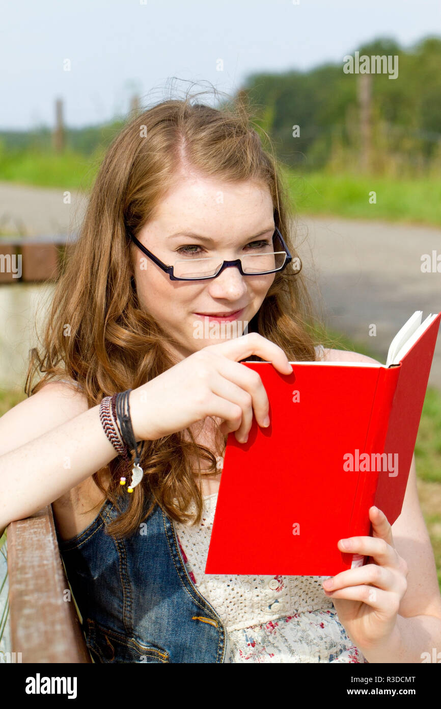 Junge Frau mit Buch in der Natur Stockfoto