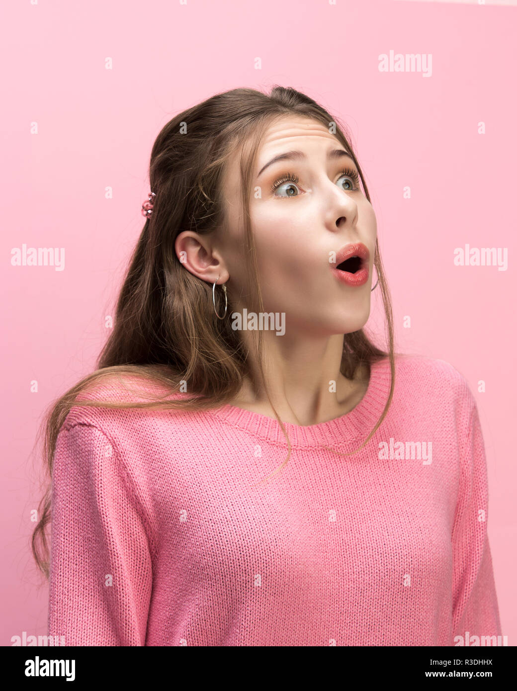 Das überrascht und erstaunt junge Frau schreiend mit offenen Mund auf rosa Hintergrund isoliert. Konzept der Schock Gesicht und menschliche Emotionen Stockfoto