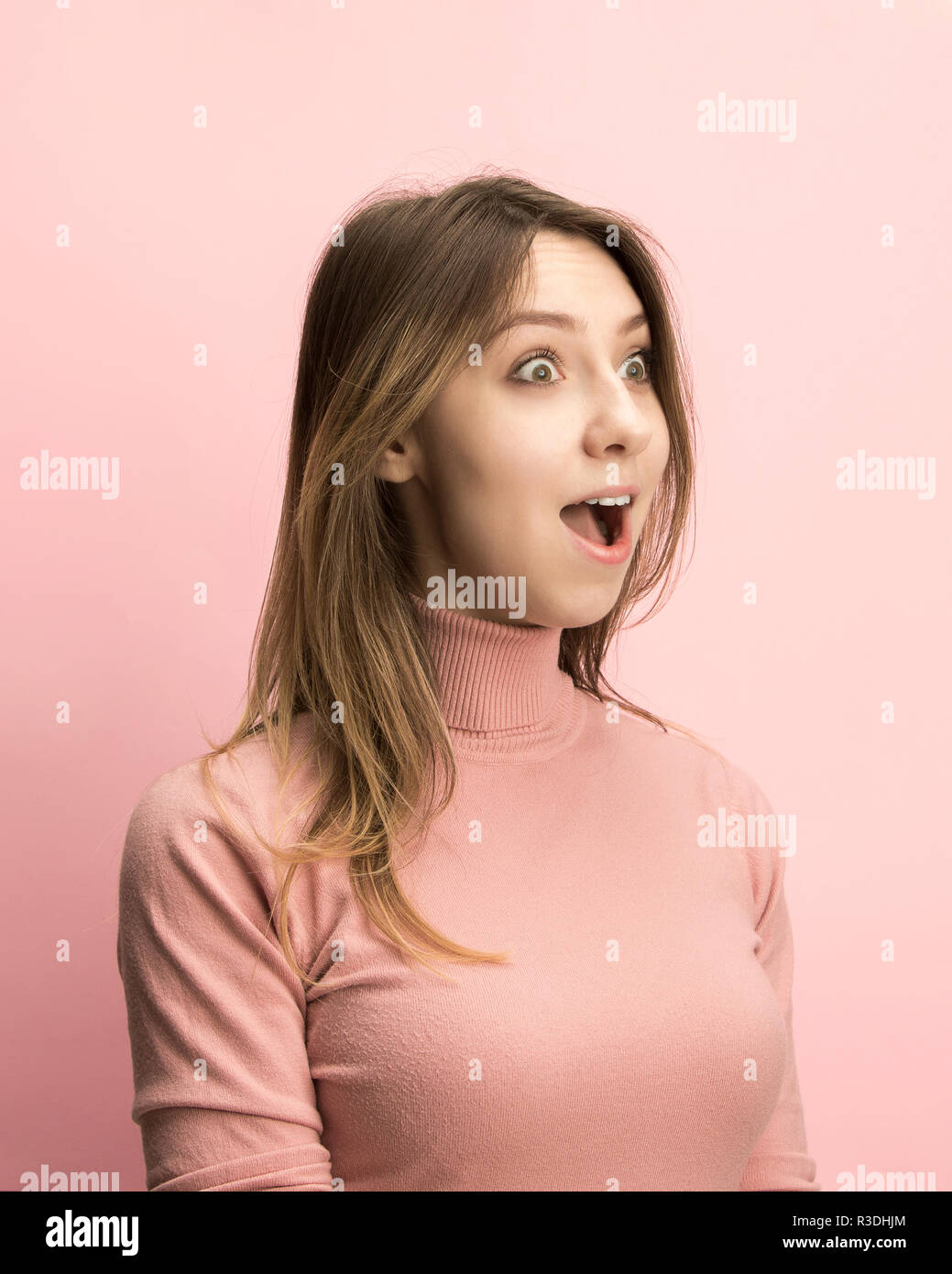 Das überrascht und erstaunt junge Frau schreiend mit offenen Mund auf rosa Hintergrund isoliert. Konzept der Schock angesichts der menschlichen Emotion Stockfoto