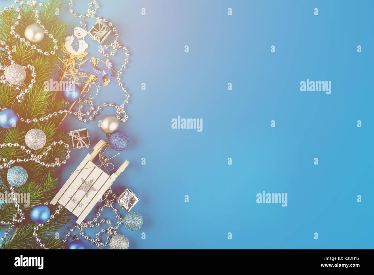 Weihnachten Grenze von Zweigniederlassungen, Fichte, silber Girlanden, blau und silber Weihnachten Kugeln und kleinen hölzernen weißen Schlitten. Flach. Festlicher Rahmen für Gree Stockfoto