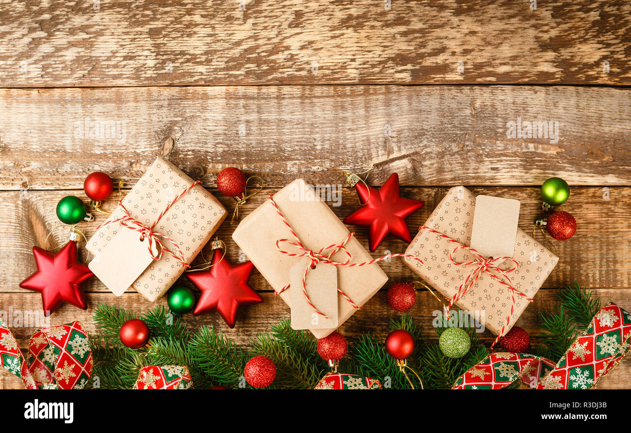 Handwerk Geschenkkarton mit roten und weißen Seil gebunden und mit grünen und roten Sternen und Kugeln aus Holz- Tabelle, Ansicht von oben eingerichtet Stockfoto