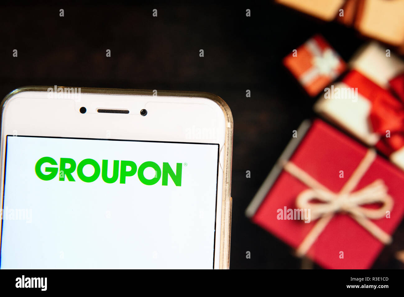 Amerikanische weltweit e-Commerce Marktplatz Groupon Logo ist auf ein Android mobiles Gerät mit Weihnachten gesehen Gaben im Hintergrund gewickelt. Stockfoto