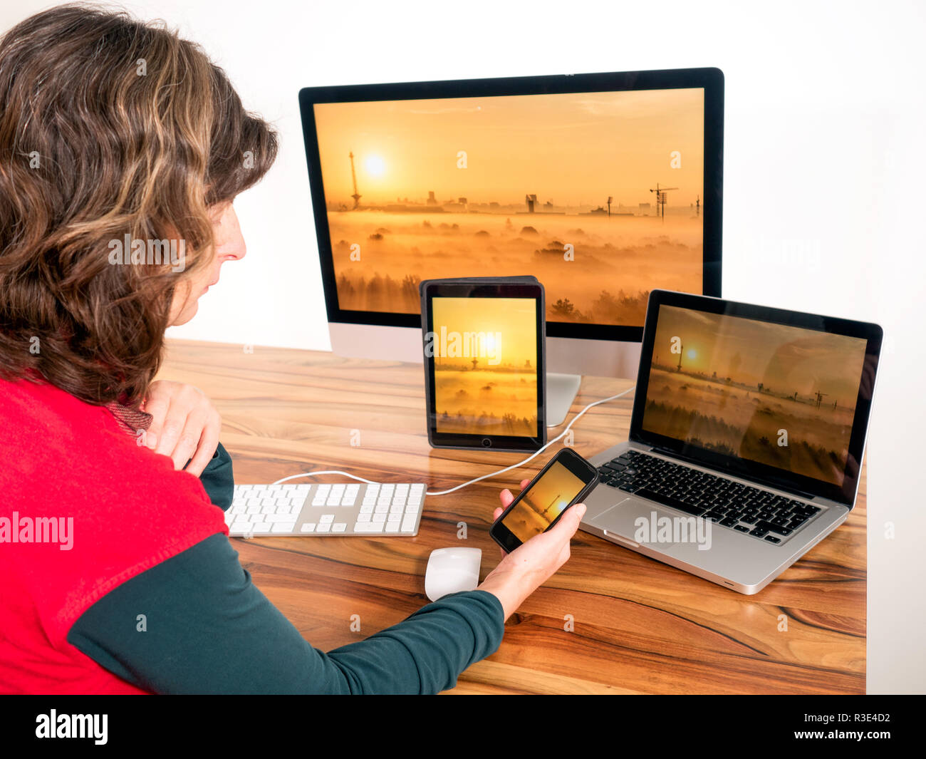 Frau mit vernetzten Computern und mobilen Geräten Stockfoto